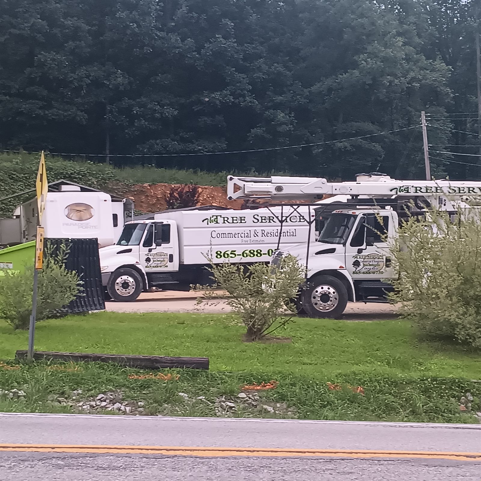 Chip truck and bucket truck parked at the yard